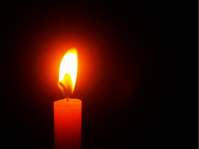 lit candle against a dark background