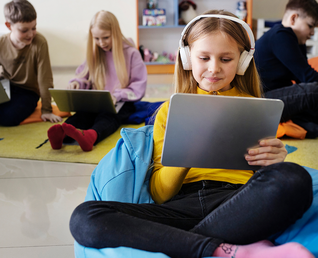 Elementary school aged children using electronic tablets and laptops